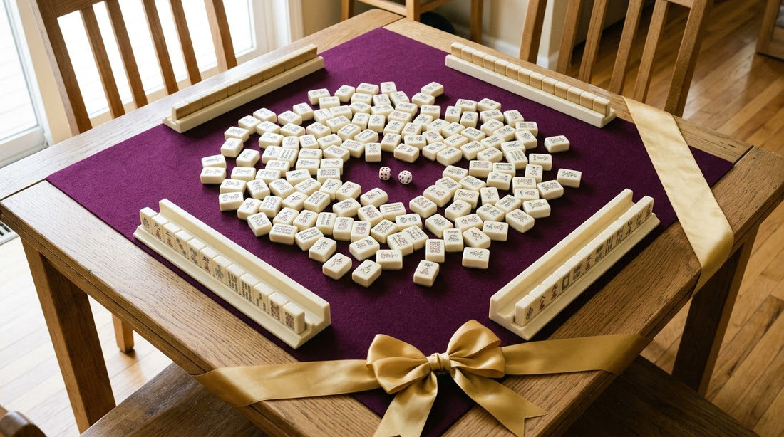 A square table set up with a plum mat, scattered tiles, four racks and dice, with a gold ribbon across one corner