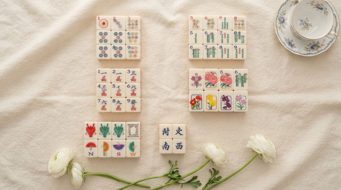 Four women compare an antique bone-and-bamboo tile with a modern acrylic one in a sunroom