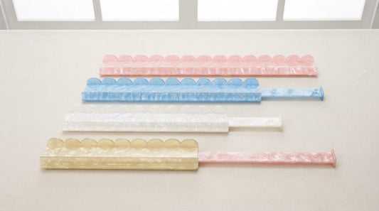 Four women compare a magnetic pusher bar and a grooved pusher at a senior center mahjong table