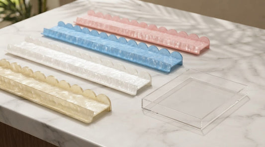 A clear acrylic mahjong rack and an iridescent pearl-shell rack compared in a quiet lounge