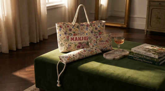 Four women unpacking mahjong tiles in a ski lodge great room with a floral travel bag nearby