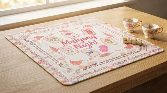 Four women unrolling a custom monogrammed mahjong mat beneath racks of ivory tiles
