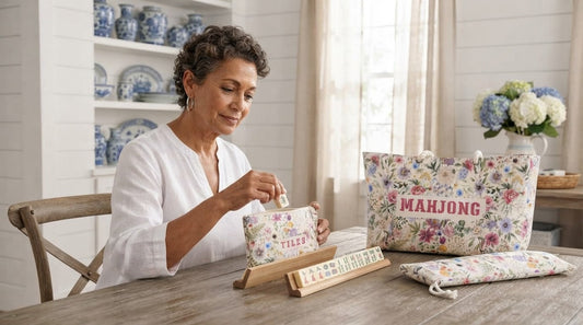 Four women playing mahjong at a square table on a screened porch overlooking the summer ocean