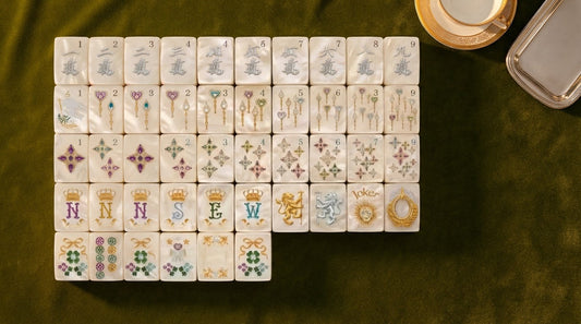 Four women admiring a luxury mahjong set's ivory tiles in a bright yacht club lounge