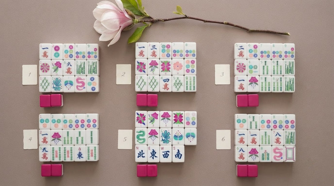 Four women in a sunlit sunroom comparing a new American mahjong set, tiles scattered mid-shuffle
