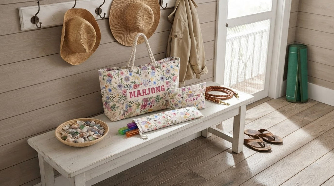 Four women playing mahjong on a breezy beach house porch with a nautical-print mat