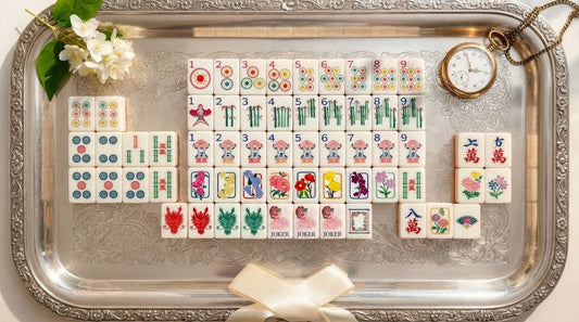 Four women studying their racks of ivory mahjong tiles in a retirement community lounge