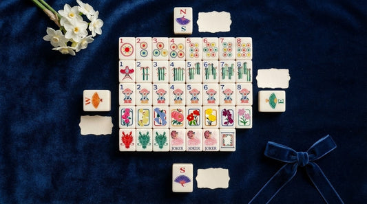 Four women drawing wind tiles for seats at a bright apartment clubhouse table