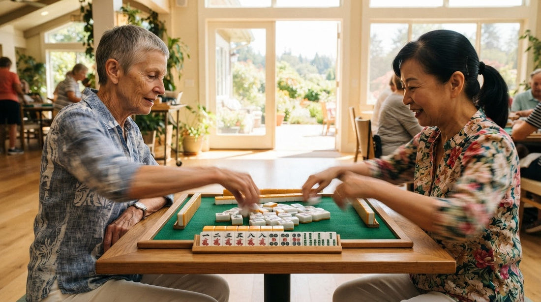 Four women playing briskly at a senior center table under ceiling fans with iced tea nearby