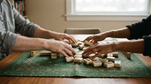 Four women at an RV park clubhouse sweeping tiles back into a pile after a misdeal