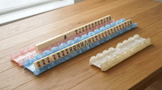 Two players each manage a pair of racks at a party room table, their tiles divided into two hands.