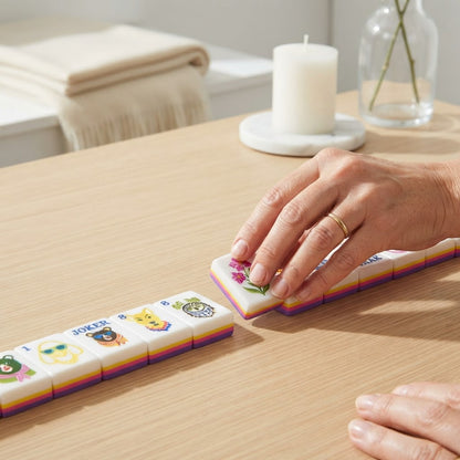Hand placing an Amalfi Lemon mahjong tile on a wood table