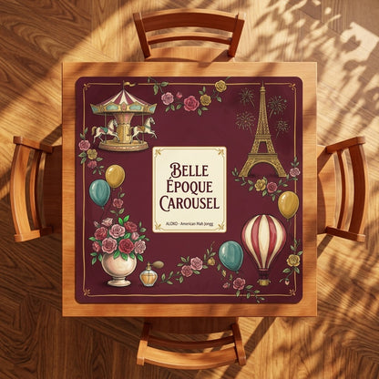 Belle Époque Fairground mahjong mat on a square card table with four chairs, seen from above