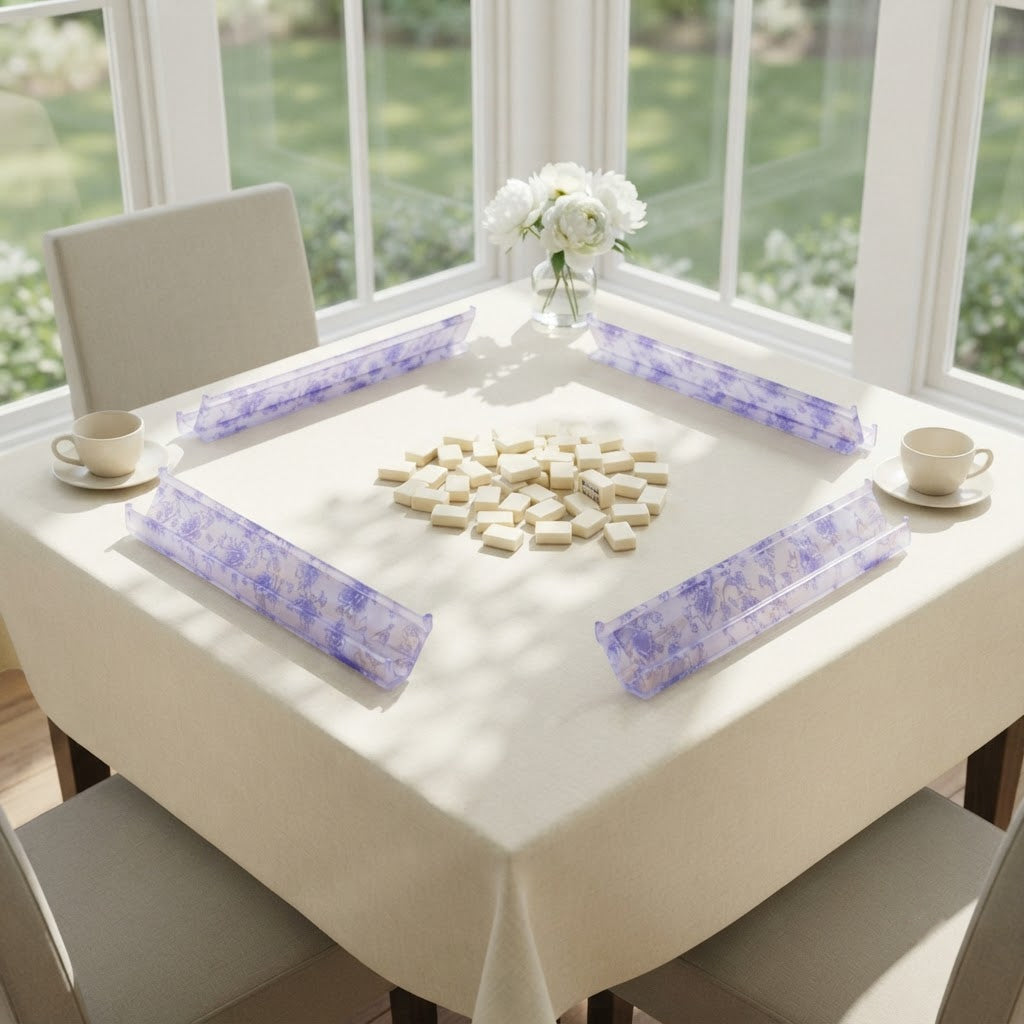 Four Blue Toile mahjong racks set out for a game on a cream tablecloth in a sunroom