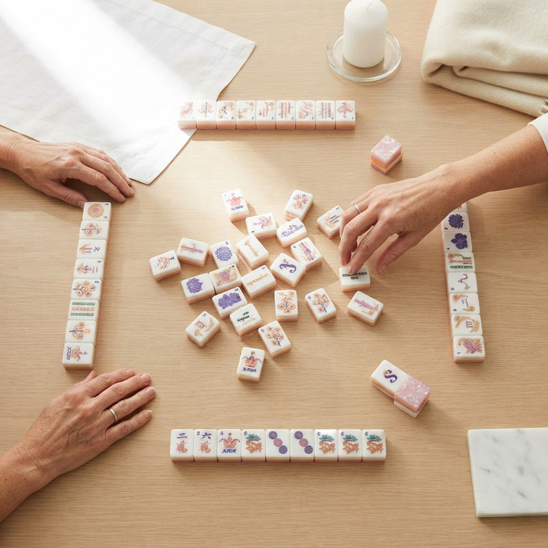 Four players mid-game with Blush Garden mahjong tiles, seen from above