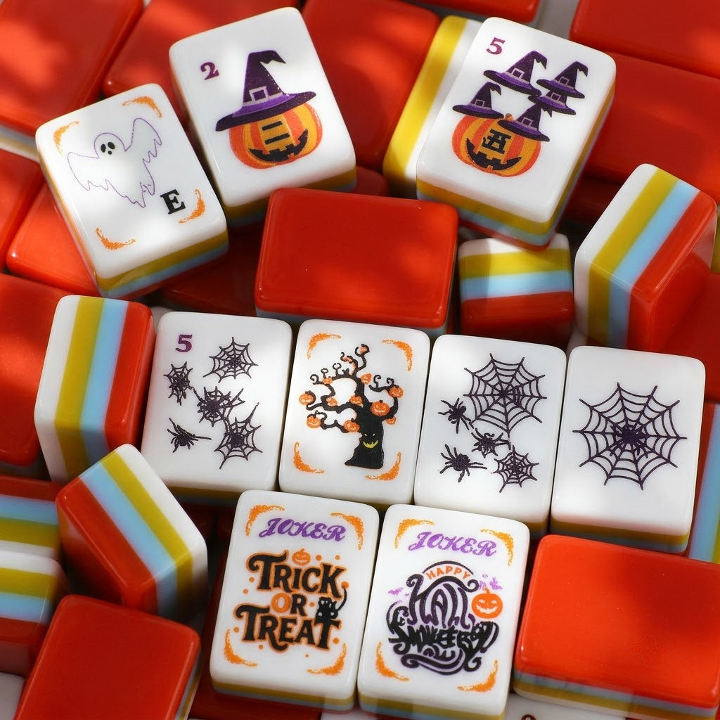 Close-up pile of Halloween mahjong tiles showing faces, backs and striped edges
