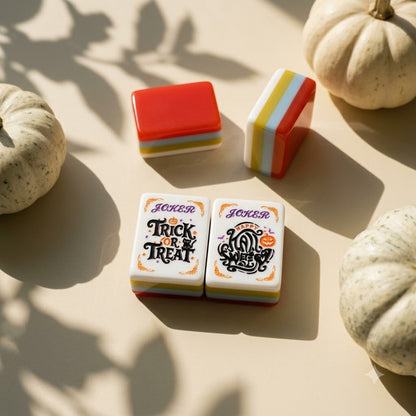 The two lettered Joker tiles beside white pumpkins
