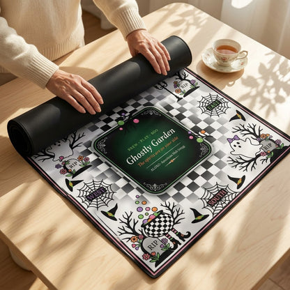 Hands unrolling the Checkerboard Ghost Garden mahjong mat across a table