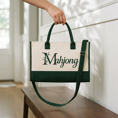 Hand holding the crossbody mahjong tote by its short handles