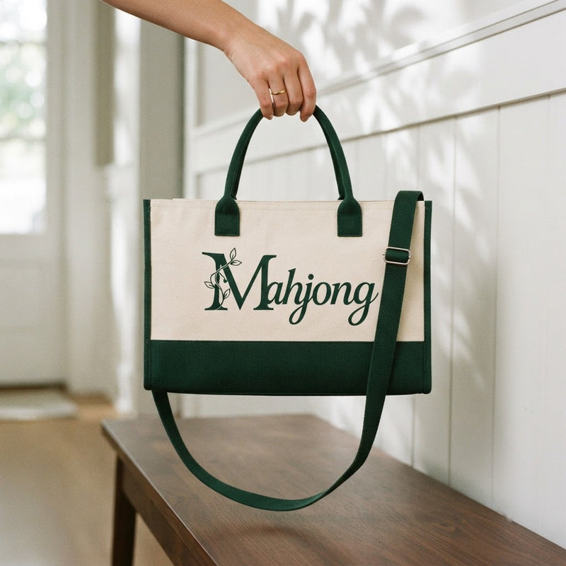 Hand holding the crossbody mahjong tote by its short handles