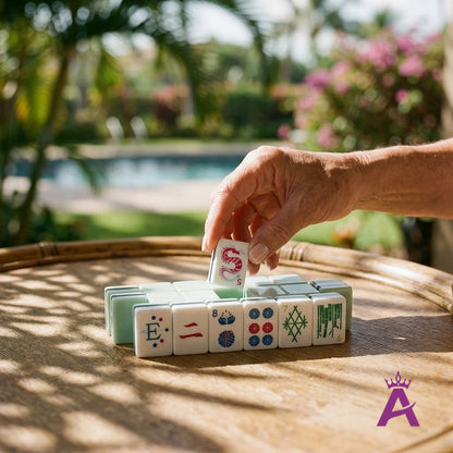 Mature woman's hand placing a crystal cyan mahjong tile poolside