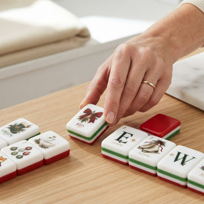 Hand placing a Fox & Holly mahjong tile on a wood table