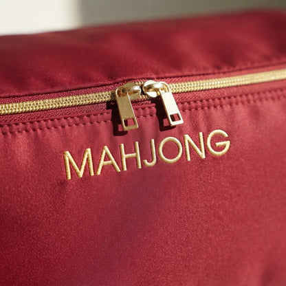 Close-up of gold MAHJONG embroidery and gold-tone zip pulls