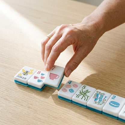A hand setting a tile down