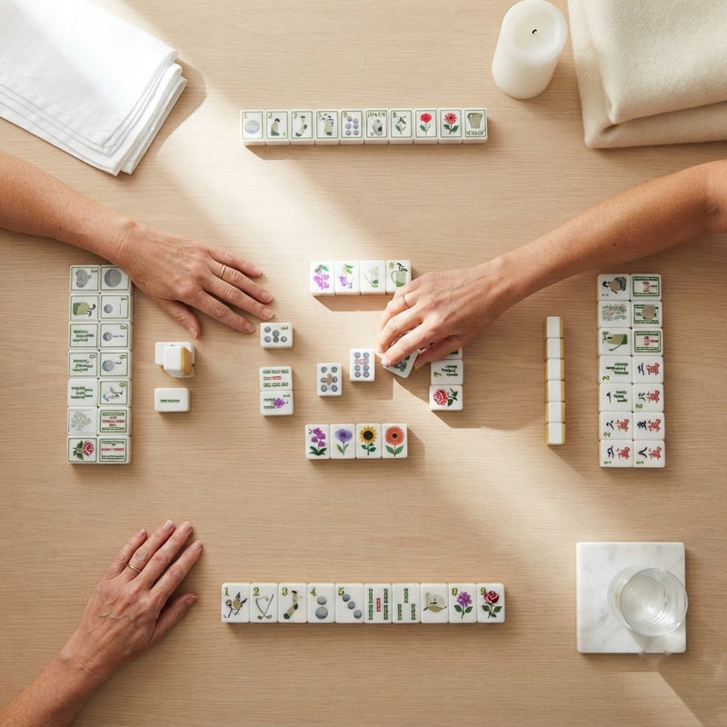 Four players mid-game with Ladies' Tee Time mahjong tiles, seen from above