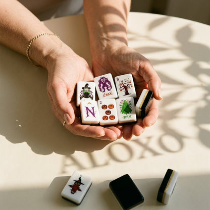 A handful of Halloween mahjong tiles cradled in a woman's hands