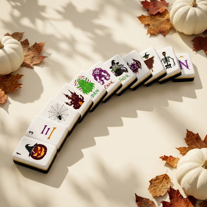 Halloween mahjong tiles fanned in an arc among autumn leaves