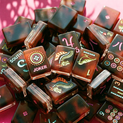 Close-up pile of neon tortoiseshell mahjong tiles showing faces, edges and backs