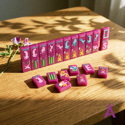 Magenta mahjong tiles standing mid-game on a wooden table