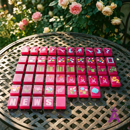 Magenta mahjong tiles on a garden terrace table with roses
