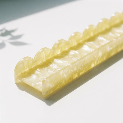 Sunlight glowing through the scalloped edge of a butter yellow Pearl Shell mahjong rack