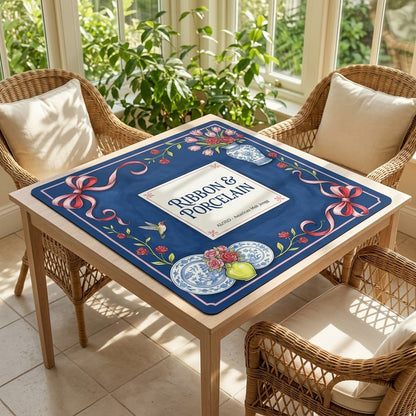 Rose Ribbon & Porcelain mahjong mat on a card table in a sunroom with wicker chairs