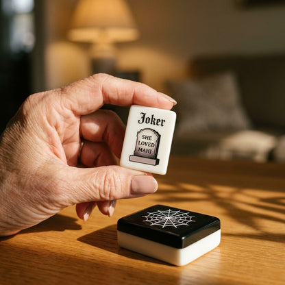 The headstone Joker held in a hand — it reads SHE LOVED MAHJ