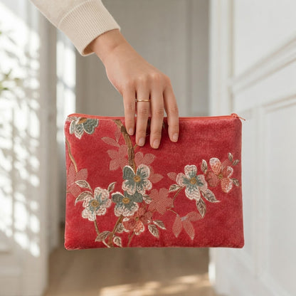 Hand holding the pink embroidered mahjong clutch