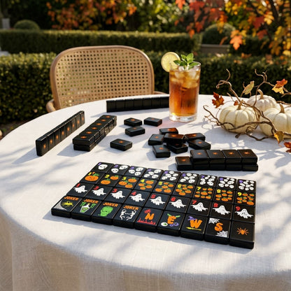 Black mahjong tiles on a linen-covered table on a sunlit autumn terrace