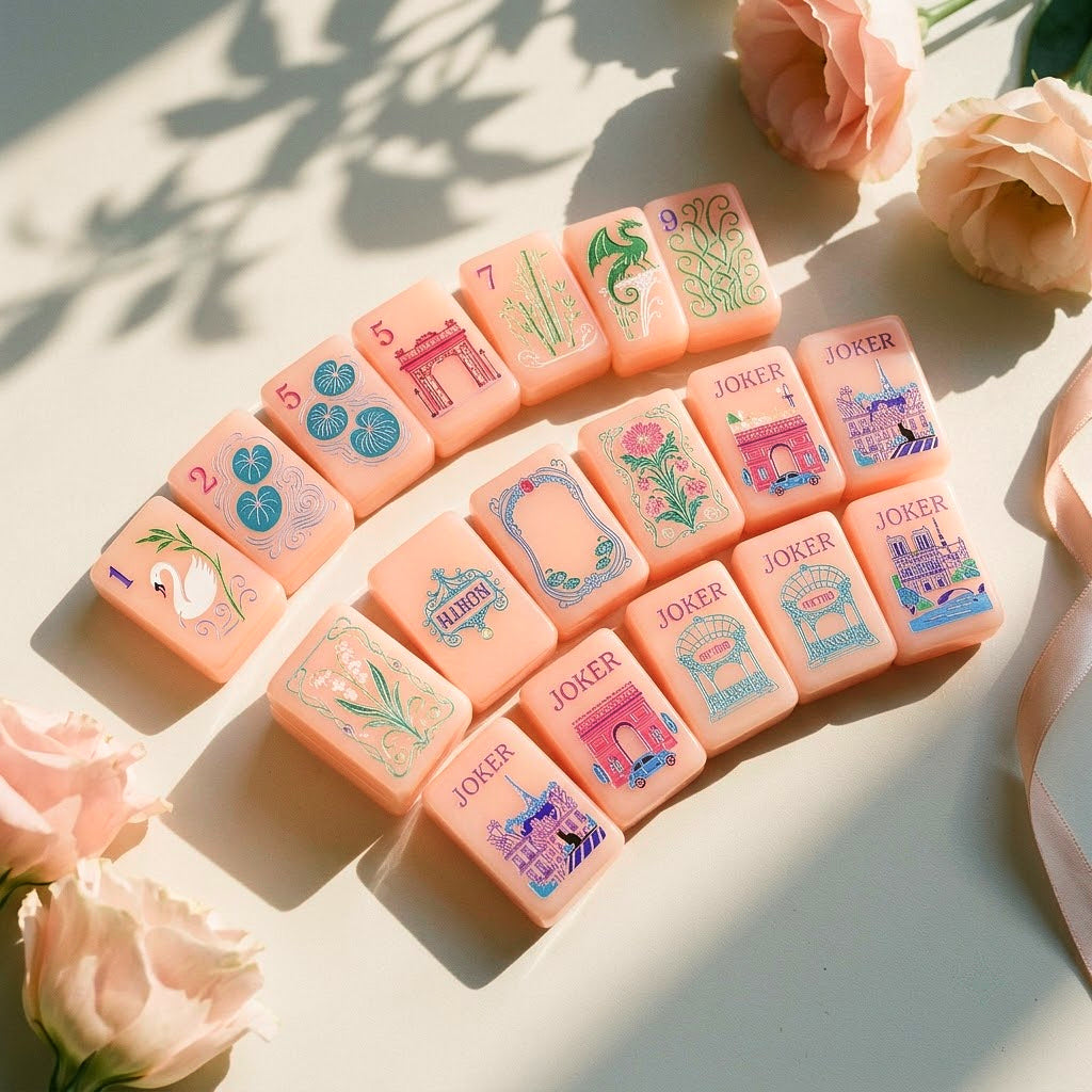 Strawberry Paris mahjong tiles fanned in an arc beside pale garden roses