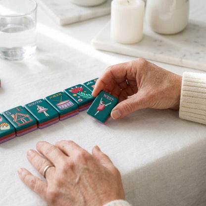 A woman's hands turning a winning tile face-up on white linen