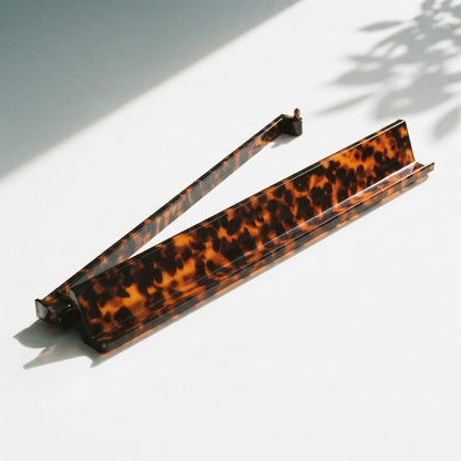 A single Tortoise Shell mahjong rack with its pusher arm swung open